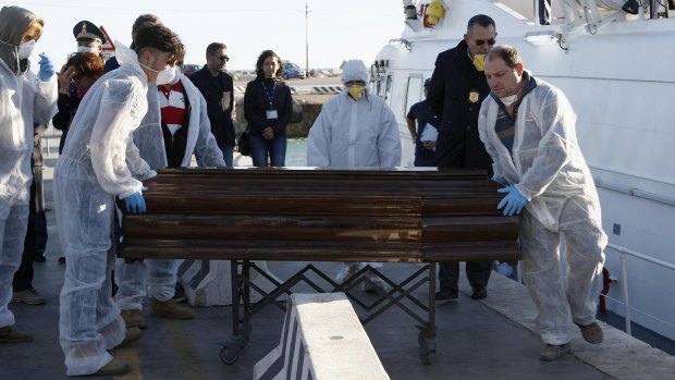 Tragedy: A coffin containing the body of a migrant who died in an inflatable boat on the Strait of Sicily is carried off a navy ship at the Sicilian harbour of Empedocle.

