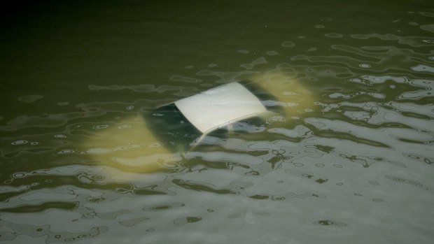 A car is submerged on a freeway flooded by Tropical Storm Harvey.