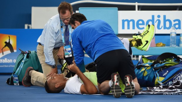 Nick Kyrgios receives treatment for his back during his first-round match.