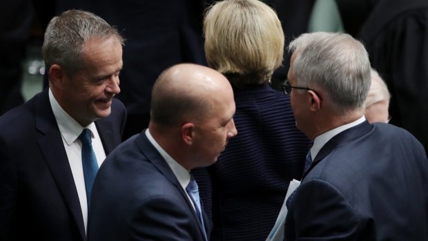 Opposition Leader Bill Shorten passes Prime Minister Malcolm Turnbull and Minister Peter Dutton during question time.