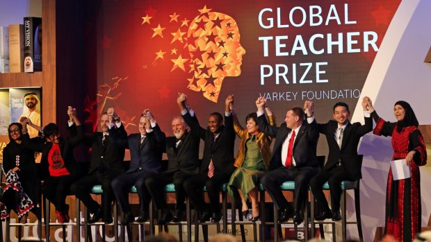 Palestinian primary school teacher Hanan al-Hroub, right, raises her hands with the other finalists. Australia's Richard Johnson is fifth from left.