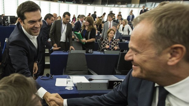 Greek Prime Minister Alexis Tsipras, left, shakes hands with Donald Tusk, president of the European Council, before delivering his speech at the European Parliament in Strasbourg, eastern France.