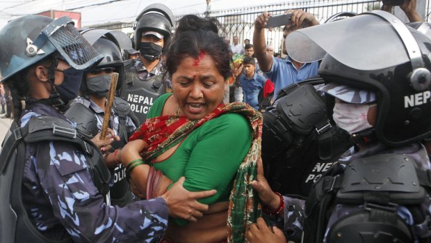 Nepalese policewomen try to stop a Hindu activist during a protest in Kathmandu on Tuesday over the country's new draft constitution.