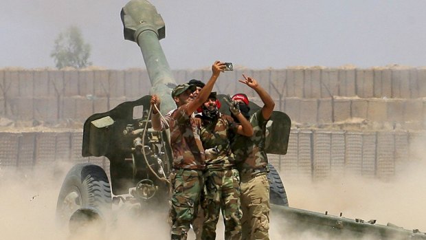 Iraq fighters take a selfie while firing artillery against Islamic State militants in Fallujah, Iraq.