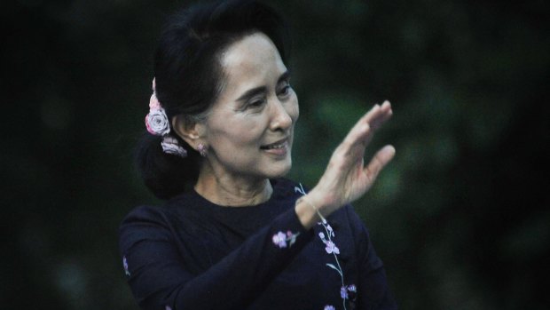 Aung San Suu Kyi waves to supporters as she leaves a late evening rally attended by more than 60,000 on Sunday.