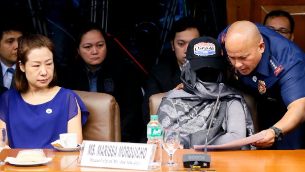 Philippines National Police Chief Ronald dela Rosa, right, shows Marissa Morquicho documents at the start of the probe. The head of the unit accused in the case has been linked to the police chief.