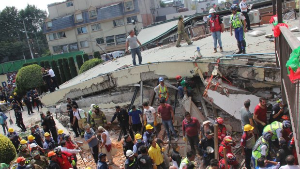 Volunteers and rescue workers search for children trapped inside at the collapsed Enrique Rebsamen school in Mexico City.