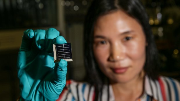 Hao Xiaojing, a lead researcher at UNSW, holds one of the new solar cells her team has developed. 