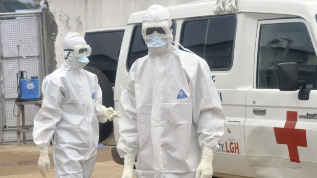 Health workers in Liberia prepare to remove the body of an Ebola victim.