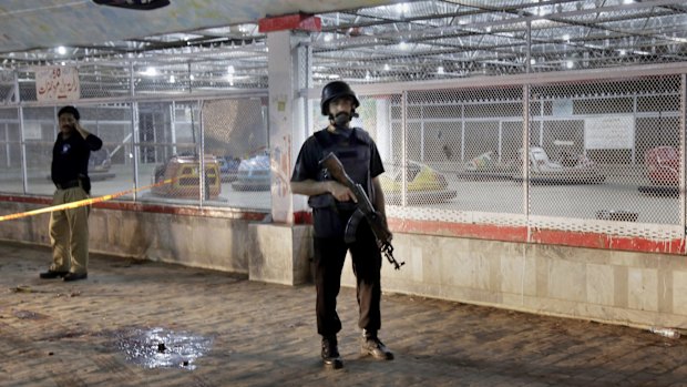 Pakistani police officers stand guard at the site of the bomb blast in Lahore on Sunday. 