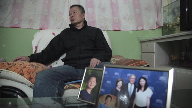 Gao Zhisheng listens to journalists in a cave home while sitting near photos of his son and and daughter in this photo taken earlier this year. 