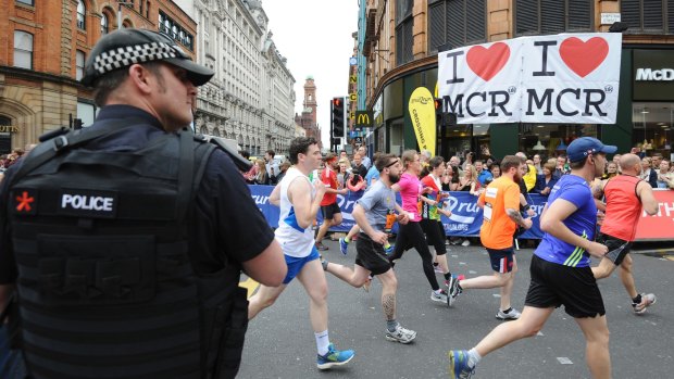 An armed police officer stands at the start of the Great Manchester Run in central Manchester, England.