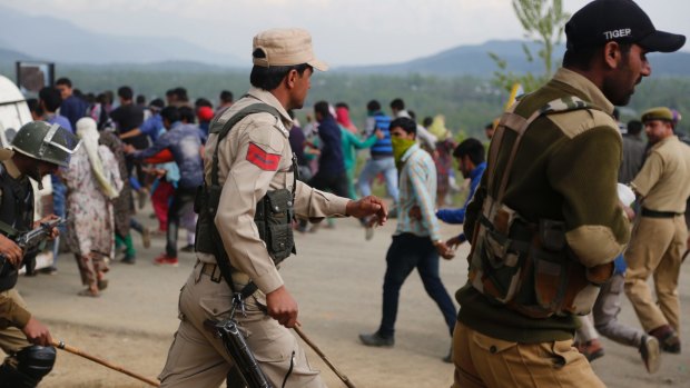 Indian police chase away Kashmiri villagers who were demanding bodies of militants killed in a gun battle on Thursday.