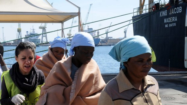 Migrants receive relief after disembarking in Palermo, Sicily, Italy on Wednesday.