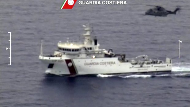 An Italian coast guard vessel is seen with a helicopter during the search and rescue operation underway after a boat carrying migrants capsized, with up to 900 feared dead, in this still image taken from video on Sunday.