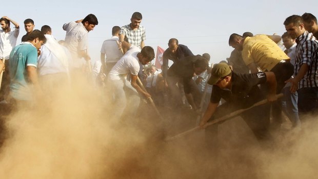 Mourners bury victims of Monday's bomb blast in Suruc, Turkey.