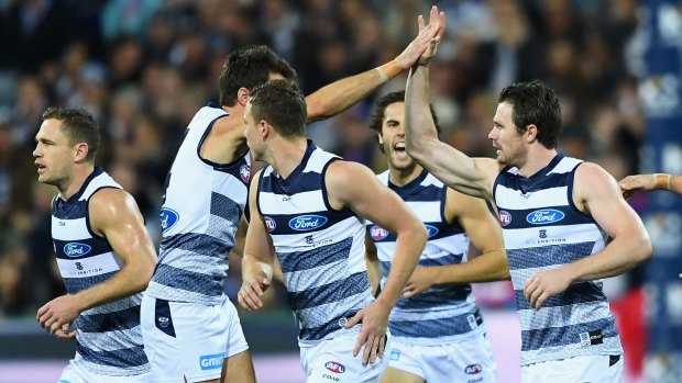 Patrick Dangerfield (right) is congratulated by teammates after kicking a goal.