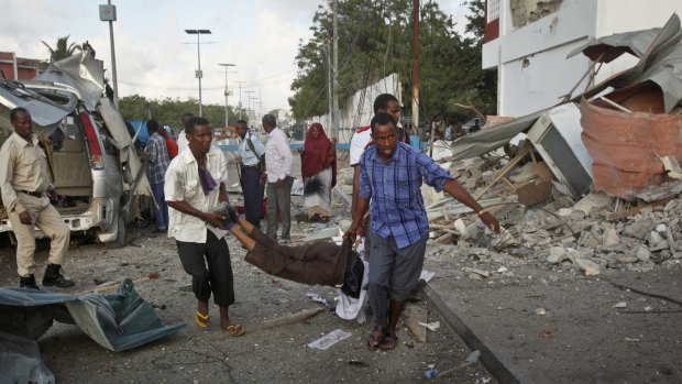 Somalis carry a wounded person to an ambulance outside the Sahafi Hotel in Mogadishu on Sunday. 