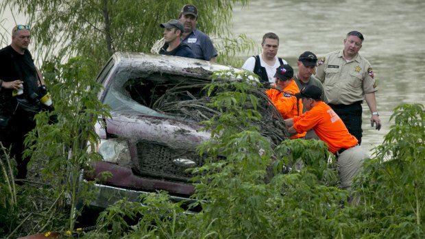 Rescue workers look inside a truck that was swept away in Austin, Texas.