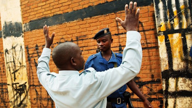 Police search a Burundi citizen as he tries to walk into a polling station during parliamentary and local elections late last month.