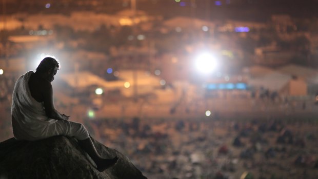 A Muslim pilgrim prays on a rocky hill called the 'Mountain of Mercy,' on the Plain of Arafat, near the holy city of Mecca, Saudi Arabia.