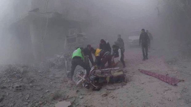 Civil Defense workers carry an injured man after government airstrikes hit Douma, near Damascus, Syria, in November.