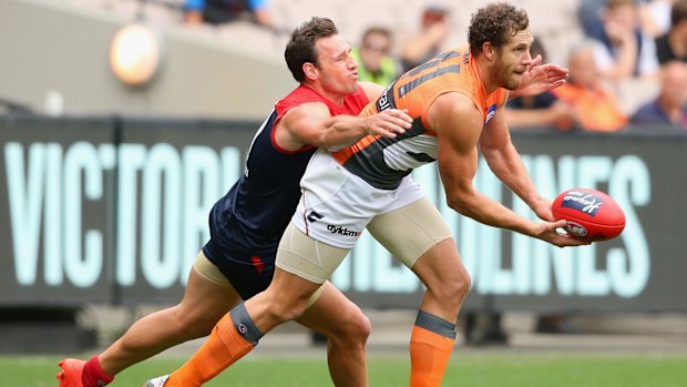 Under pressure: Shane Mumford of the Giants handballs despite being tackled by Cameron Pedersen.