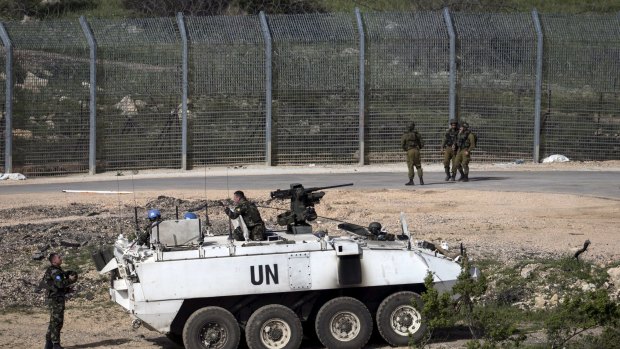 Israeli soldiers and members of UN peacekeeping forces near the frontier with Syria on Monday.
