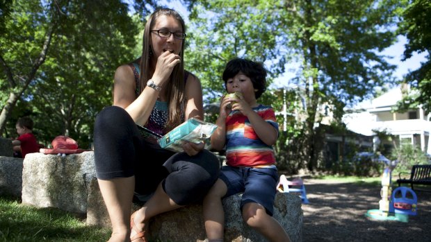 Becky Lopes-Filho and her son Sebastian Lopes-Fihlo, 4, eat seaweed rice crackers and a pear in a park in Cambridge, New York.