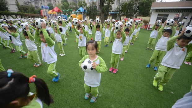 Kindergarten children do choreographed football exercises to teach them football culture at Yangzhou University Kindergarten, Jiangsu, China, on Tuesday.