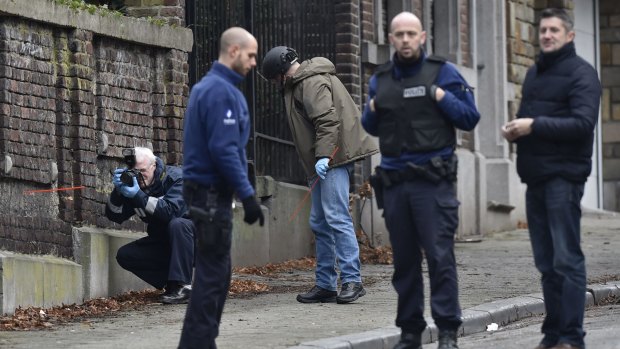 A forensic team members work at Colline street in Verviers, eastern Belgium, after police shot dead two suspects in a gun battle after they opened fire on officers with heavy weapons, and arrested a third man. 