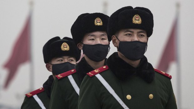 Chinese Paramilitary police wear masks to protect against pollution as they march during smog in Tiananmen Square on Wednesday. 