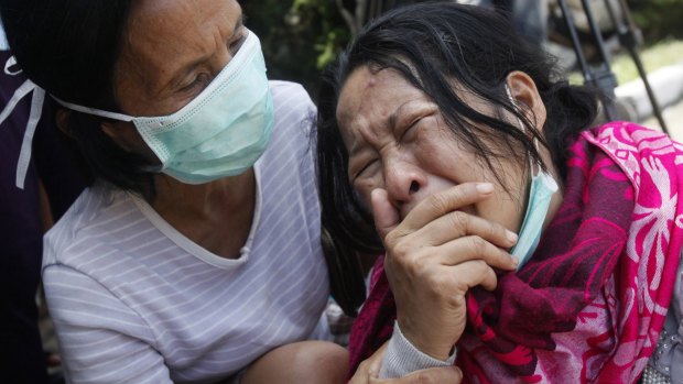 Family members of passengers on a military plane that crashed onto a residential area weep at a hospital in Medan, North Sumatra, in June, 2015.