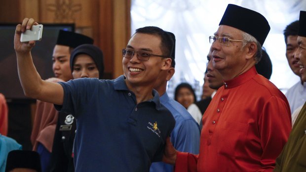 Malaysian Prime Minister Najib Razak, right, poses for a selfie at his open house earlier this month.