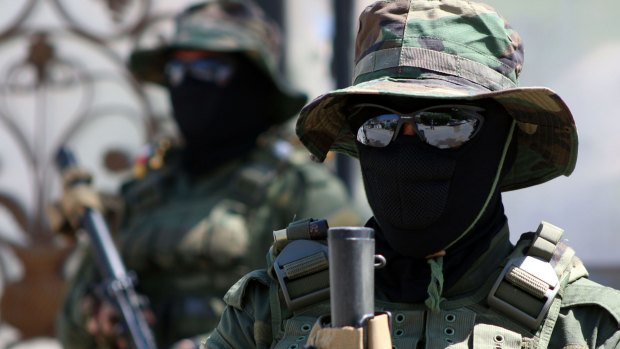 Iraqi fighters of the Shiite militia Asaib Ahl al-Haq (The League of the Righteous) stand guard outside their headquarters in the Iraqi mainly Shiite southern city of Basra on Monday. 