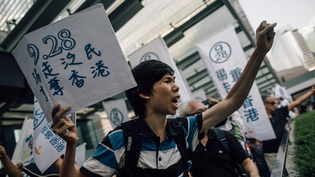 Pro-government supporters march by the pro-democray protest site in Hong Kong.