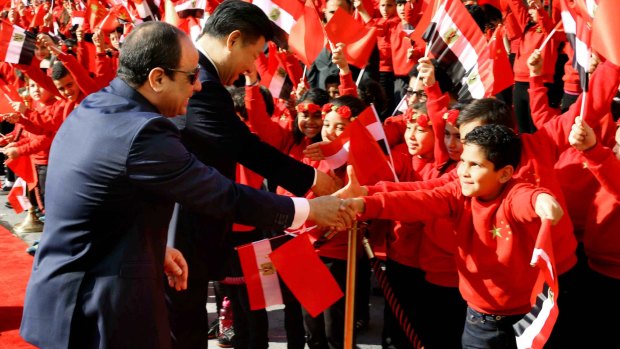 Egyptian President Abdel-Fattah el-Sissi, left, and Chinese President Xi Jinping, shake hands with children at the Presidential Palace in Cairo, Egypt on Thursday. Jinping is on a two-day visit to the country. 
