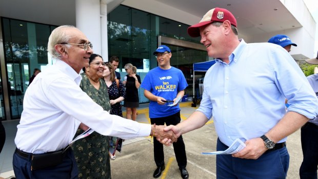 Queensland Opposition leader Tim Nicholls (right) hands out how-to-vote cards in Upper Mt Gravatt, Brisbane, this week during the Queensland Election campaign.