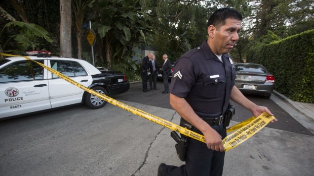 A police officer creates a perimetre outside the home of Andrew Getty in the Hollywood Hills area of Los Angeles.