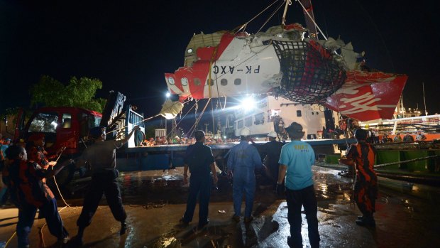 The tail section of the AirAsia Airbus A320 flight QZ8501 is loaded onto a truck at port in Kumai, Indonesia.