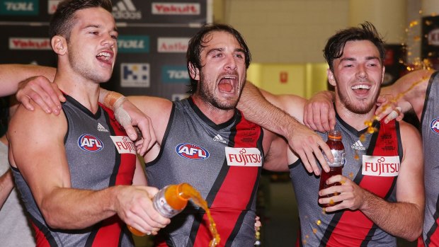 Bombers Patrick Ambrose, Jobe Watson and Michael Hibberd  celebrate the win over St Kilda this year wearing the grey jumper.