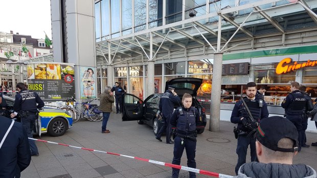 A car stands in front of a store, guarded by police in Heidelberg, Germany, on Saturday.