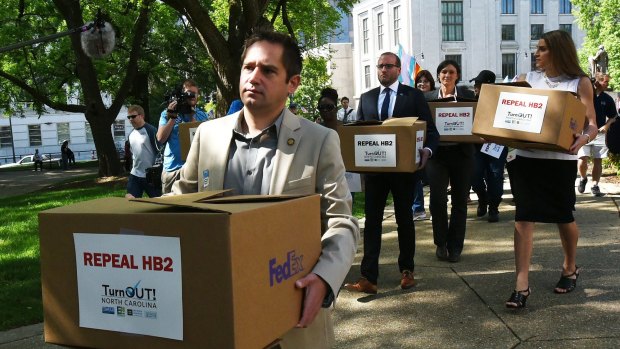 The executive director of Equality North Carolina, Chris Sgro, leads a group carrying petitions calling for the repeal of House Bill 2 to governor Pat McCrory's office.