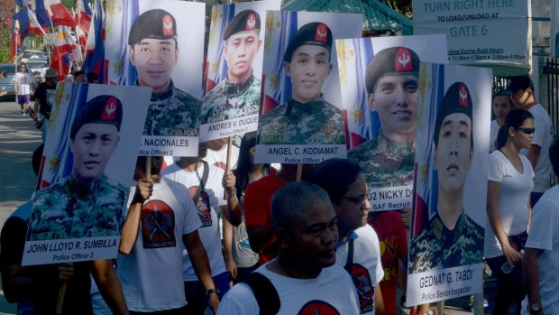 Family and supporters hold pictures of some of the 44 police commandos killed in the hunt for Malaysian Zulkifli bin Hir, also known as Marwan, blamed for the 2002 Bali bombings in Indonesia in which 202 people died.