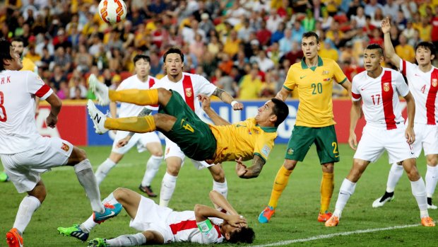 Up in the air: Tim Cahill opens the scoring against China in some style.