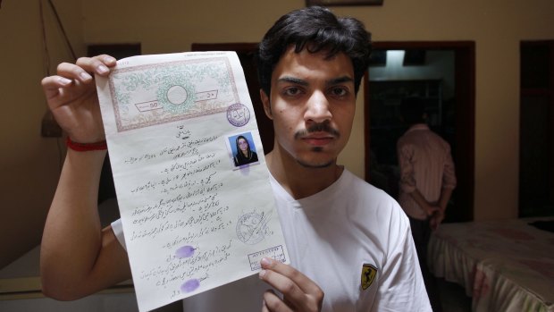 Hassan Khan shows his marriage certificate to media at his home in Lahore, Pakistan on Wednesday.