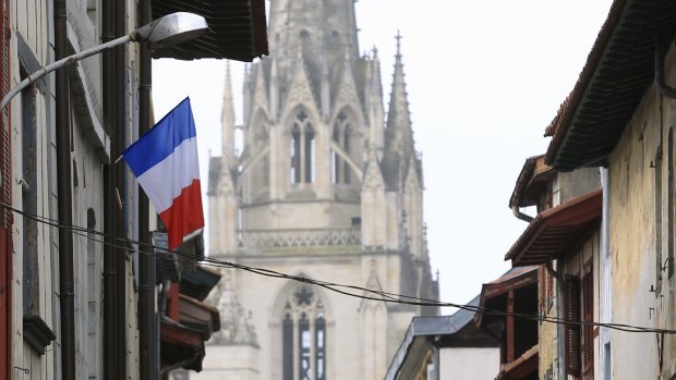 A French flag hangs from a balcony in Bayonne, south-western France, on Thursday. 