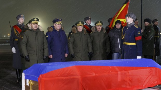 Russian Defence Minister Sergei Shoigu, front left, and other military officials pay their respects as they stand by the coffin of Russian Lieutenant Colonel Oleg Peshkov, after his body was transported from Turkey, at a mourning ceremony outside Moscow.