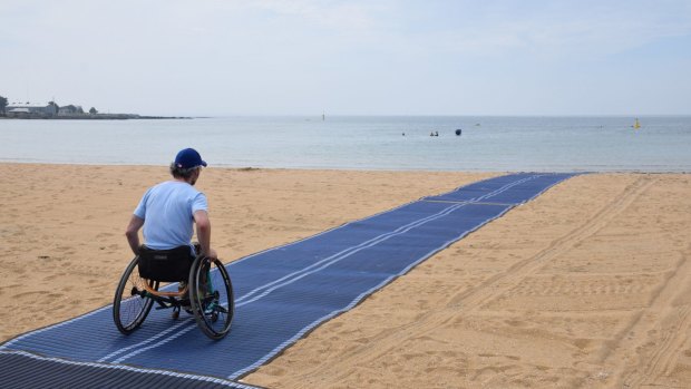 Brook Quinn tests the wheelchair-accessible matting at Williamstown Beach. 