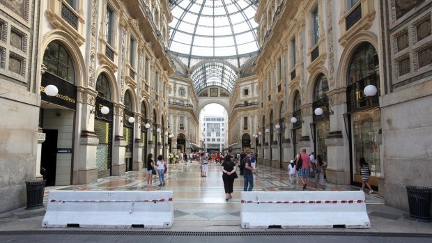 Hastily placed barriers to prevent vehicles from entering greet tourists at the Vittorio Emanuele gallery in Milan.